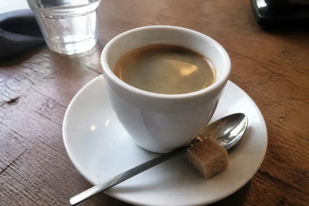 Tasse de café américain, cuillère et sucre sur table en bois rustique