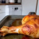 Cuisse de poulet au four dorée sur plaque de cuisson dans une cuisine moderne