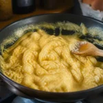 Oeufs brouillés crémeux dans poêle avec cuillère en bois en cuisson calories contrôlées